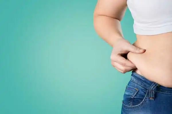 Image of woman pinching her love handles to show weight gain Swansea