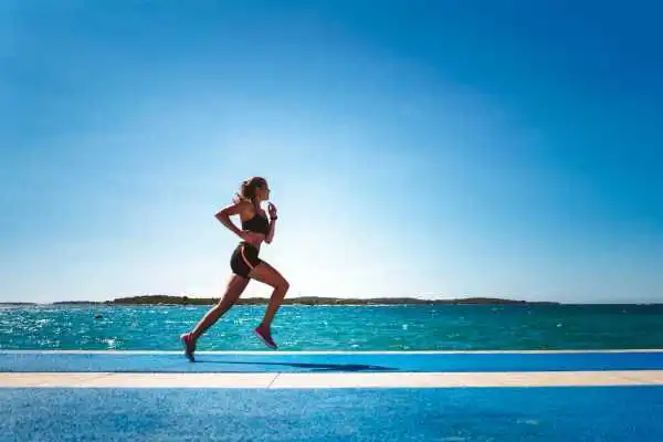Woman running showing strong leg muscle Swansea